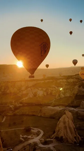 Hot air balloons flying over Göreme at sunrise in Cappadocia